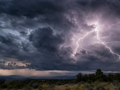 A dramatic scene of the night sky showing lightning through the clouds